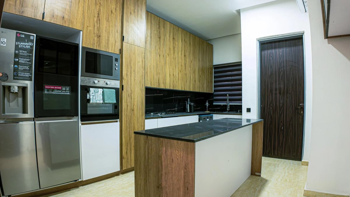 Fitted kitchen with island and built-in appliances in a completed Golf View residence