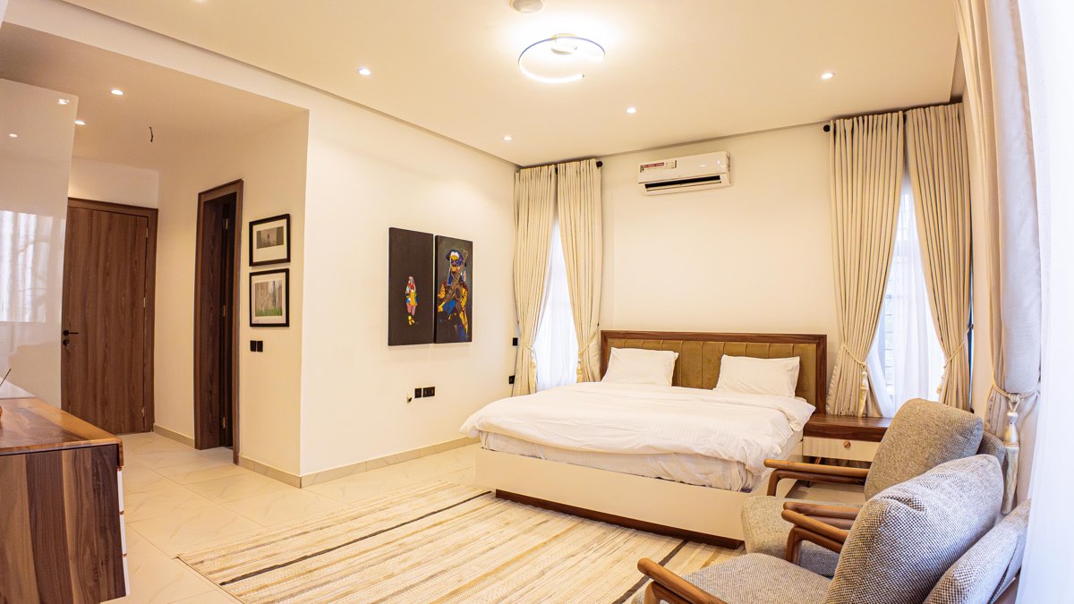 Master bedroom with upholstered headboard in a completed Golf View residence